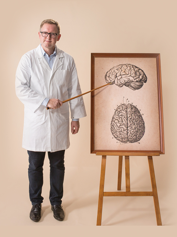 scientist standing net to brain picture